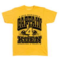 Black ink on a yellow shirt that reads "Koen Entrigner. Captain Koen. Defensive Back. Ypsilanti, MI" over an illustration of a football field with a large number 4 in the center and a football helmet to either side.