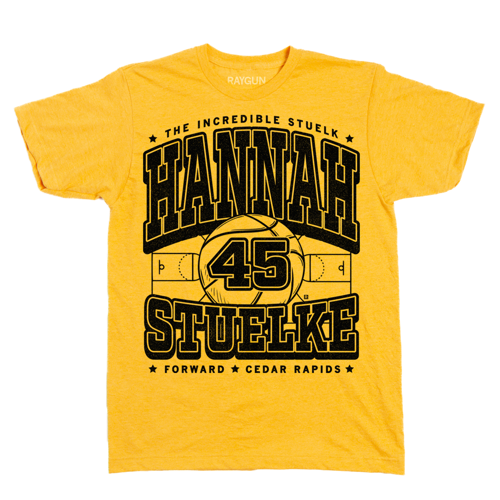Gold shirt with black print that says, "The Incredible Stuelk. Hannah Stuelke. Forward. Cedar Rapids" over an illustration of a giant basketball and a basketball court.