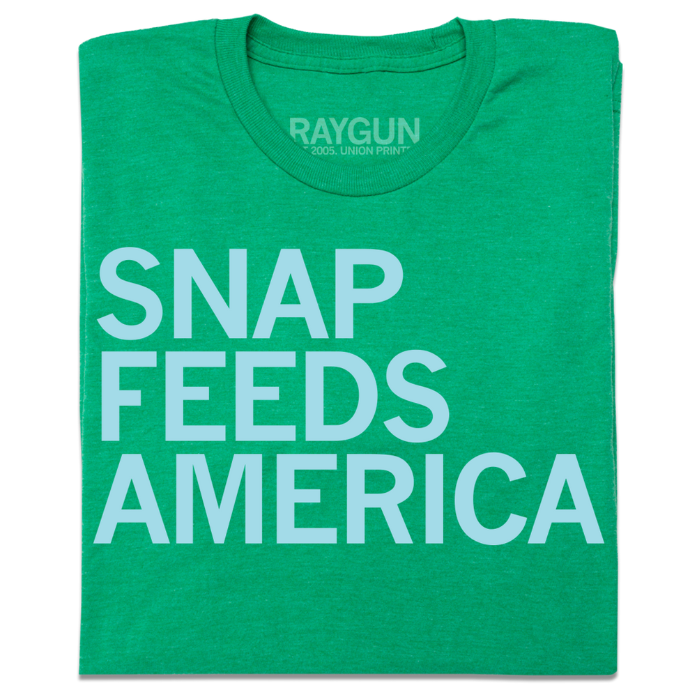A folded Heather Kelly Green shirt with ice blue text that reads "Snap feeds America" left aligned