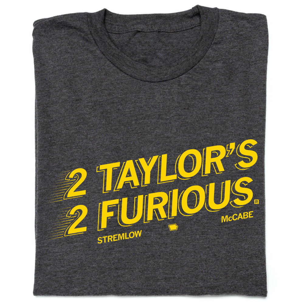 Folded charcoal t-shirt with gold ink text that reads "2 Taylors 2 Furious. Stremlow. McCabe."