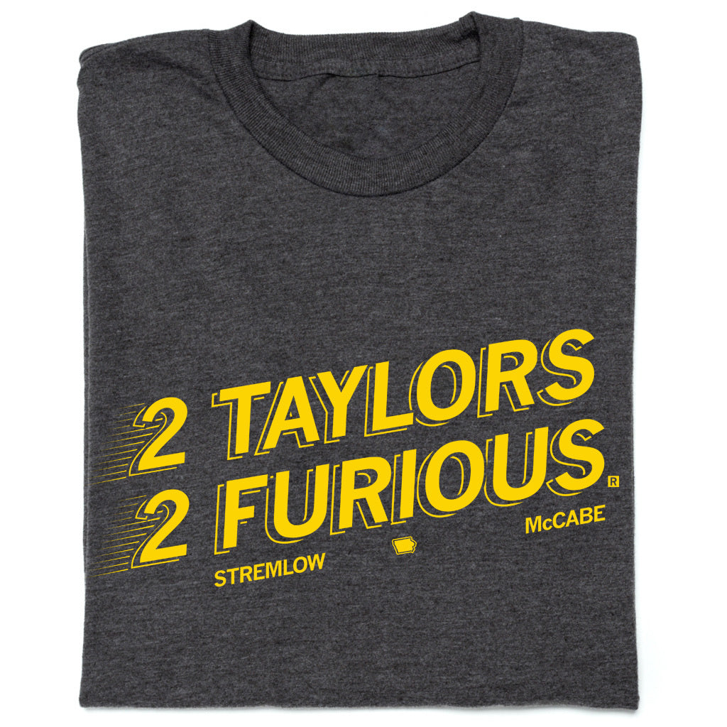 Folded charcoal t-shirt with gold ink text that reads "2 Taylors 2 Furious. Stremlow. McCabe."