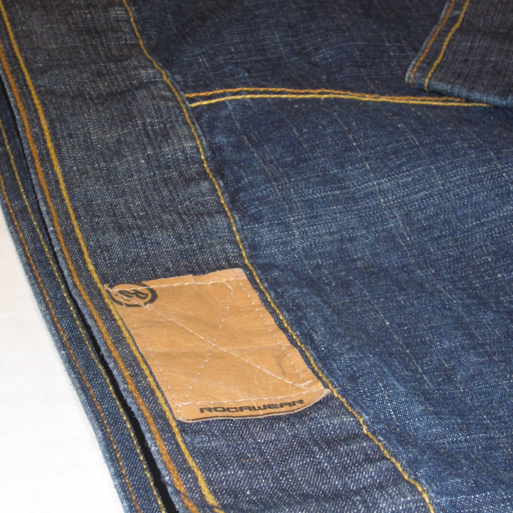 Dark blue vintage Rocawear denim jacket with yellow topstitching and a tan leather patch.