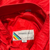 Inside the collar of a red Members Only jacket is a brand tag with a rainbow graphic and a size 46 label.