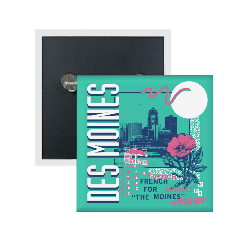 A teal square metal button in a retro 90's style with a navy print image of the Des Moines skyline. Sideways, vertical white text on the left says, "Des Moines" with pink & blue text to the bottom right that reads "French for The Moines." Accents images include a pink flower, pink outline of The Travelers building, and other colorful images.