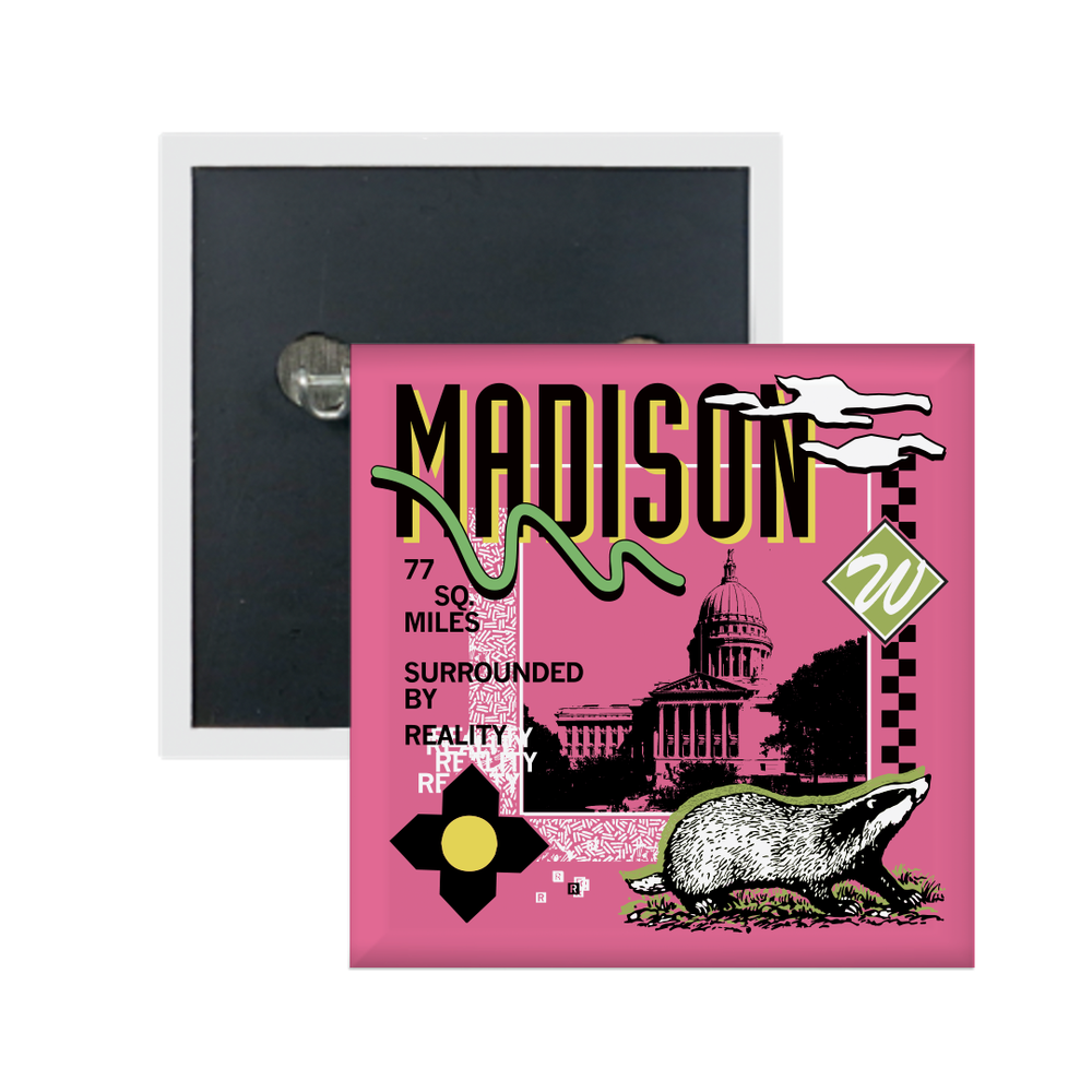 A pink square metal button in a retro 90's style with a black print image of the Wisconsin Capitol building in Madison. Black text  across the tops says, "Madison" with more text to the left that reads, "77 sq. miles surrounded by reality." There's also a black and white badger, green squiggle, white clouds, and other colorful accents.