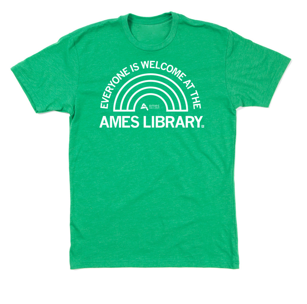 Green union-made t-shirt featuring a white graphic of a rainbow and the text EVERYONE IS WELCOME AT THE AMES LIBRARY.