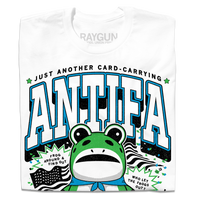 Folded white t-shirt with the text "Just another card-carrying ANTIFA member" above and below an illustration of the Portland protestor in a frog suit. To the sides are an American flag and the text "Frog around & find out. Who let the frogs out?"