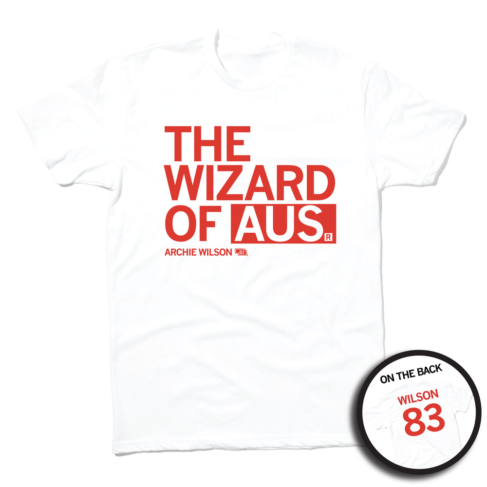Short-sleeve white t-shirt with left-aligned red text that says, "THE WIZARD OF AUS" with "ARCHIE WILSON" in smaller text below. To the right of his name is an outline of Nebraska with the number "83" in its center. A circular picture to the bottom right shows the back of the shirt. The back is printed like a jersey with "WILSON" above a large 83.