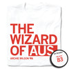 A folded white t-shirt with left-aligned red text that says, "THE WIZARD OF AUS" with "ARCHIE WILSON" in smaller text below. To the right of his name is an outline of Nebraska with the number "83" in its center. A circular picture to the bottom right shows the back of the shirt. The back is printed like a jersey with "WILSON" above a large 83.