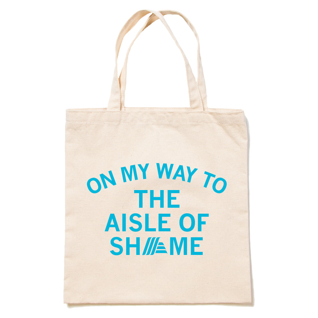 Beige canvas RAYGUN tote bag with peacock blue text that reads ON MY WAY TO THE AISLE OF SHAME, where the letter A in SHAME is replaced by the Aldi logo.