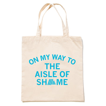 Beige canvas RAYGUN tote bag with peacock blue text that reads ON MY WAY TO THE AISLE OF SHAME, where the letter A in SHAME is replaced by the Aldi logo.