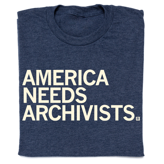 A navy blue, union-made t-shirt with the cream-colored text AMERICA NEEDS ARCHIVISTS printed on the front.