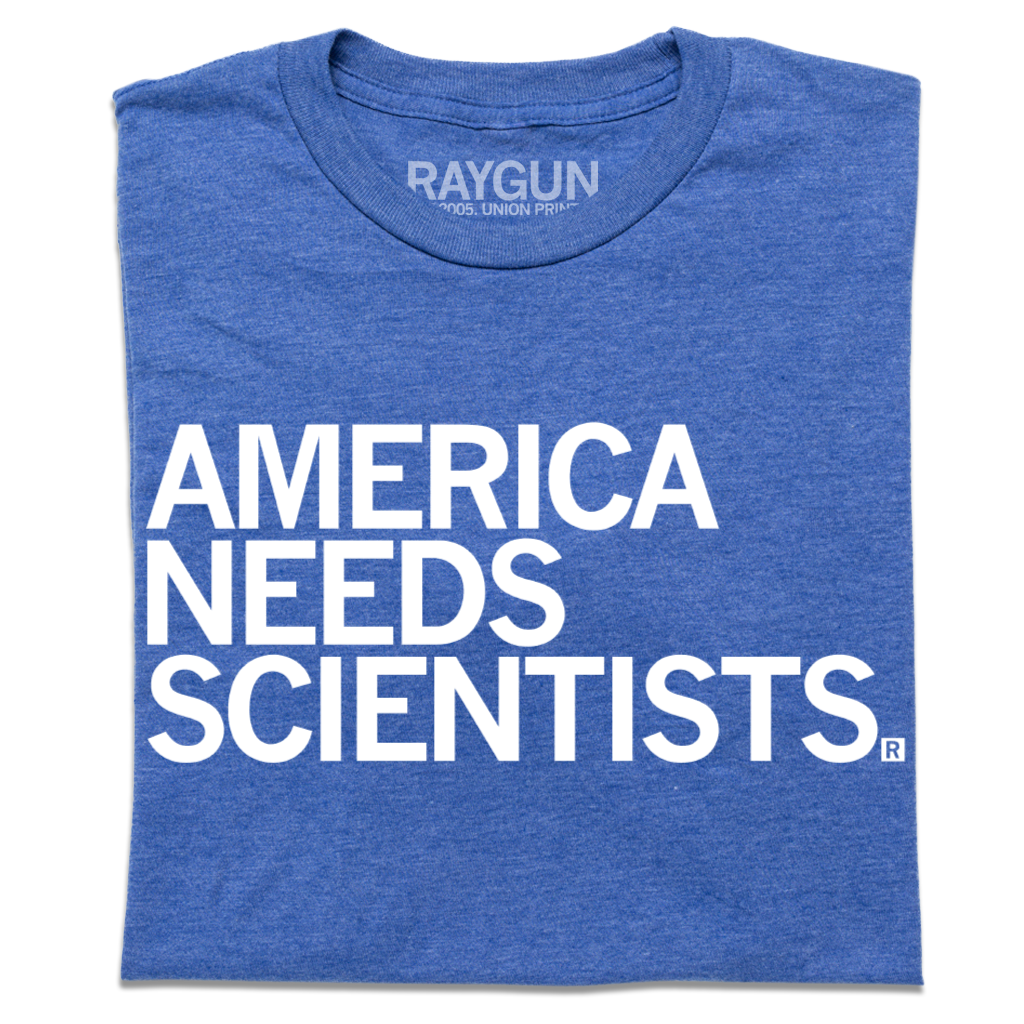 Blue t-shirt printed in the USA with the text AMERICA NEEDS SCIENTISTS in white capital letters.
