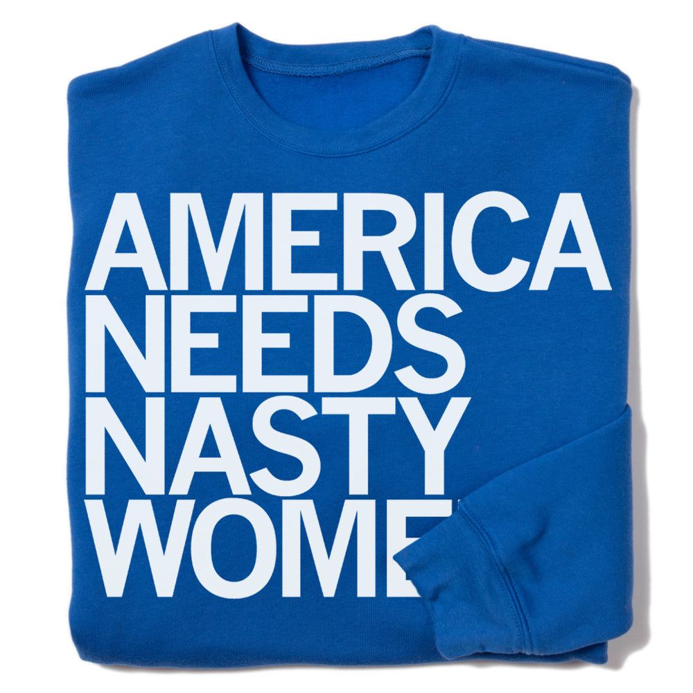 A folded royal blue sweatshirt with left-aligned white print text that reads "AMERICA NEEDS NASTY WOMEN."