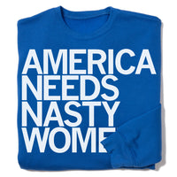 A folded royal blue sweatshirt with left-aligned white print text that reads "AMERICA NEEDS NASTY WOMEN."