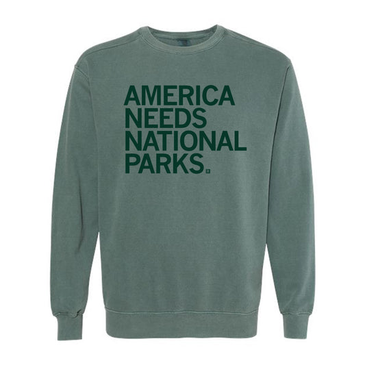 Union-made green crewneck sweatshirt with the text AMERICA NEEDS NATIONAL PARKS. printed in dark green.
