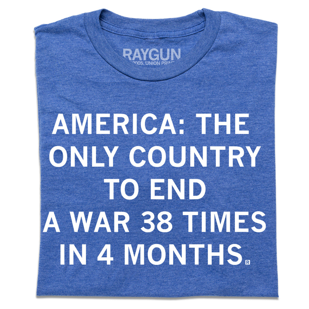 A folded heather blue t-shirt with centered white text that says, "America: The Only Country To End A Ware 38 Times In 4 Months."