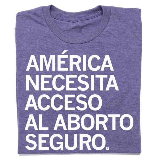 Heather purple RAYGUN t-shirt with the white text AMÉRICA NECESITA ACCESO AL ABORTO SEGURO. printed on the front.