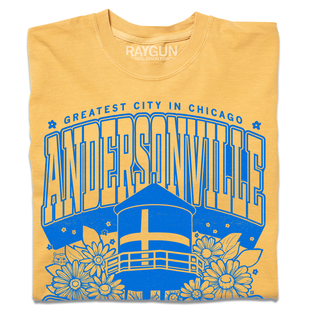 Folded heather mellow yellow t-shirt with bright blue print. Text from top-to-bottom reads "GREATEST CITY IN CHICAGO. ANDERSONVILLE. CHICAGO. SWEDE SOMMAR CHILD." There's an illustration of the Andersonville Swedish flag water tower in the center, surrounded by flowers.