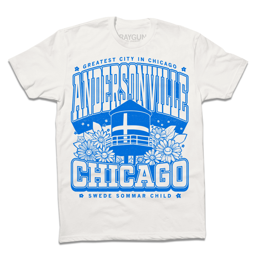 White t-shirt with bright blue print. Text from top-to-bottom reads "GREATEST CITY IN CHICAGO. ANDERSONVILLE. CHICAGO. SWEDE SOMMAR CHILD." There's an illustration of the Andersonville Swedish flag water tower in the center, surrounded by flowers.