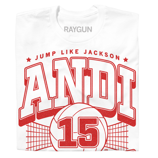 White Andi Jackson T-shirt with a red graphic featuring a volleyball, a net, the number 15, the text JUMP LIKE JACKSON, and the name ANDI in large varsity-style letters.