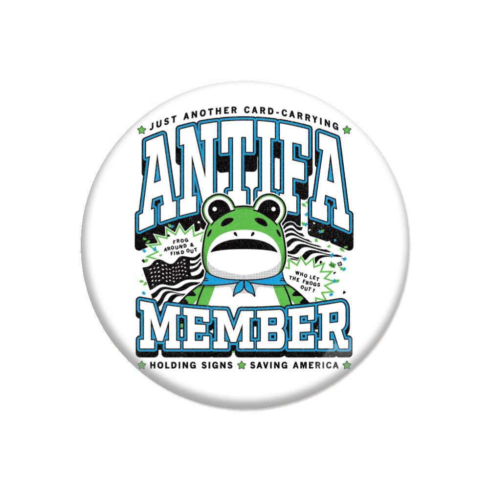 A round ANTIFA button featuring a cartoon frog wearing a blue bandana, with the text ANTIFA MEMBER and small signs that read FROG AROUND & FIND OUT and WHO LET THE FROGS OUT?.