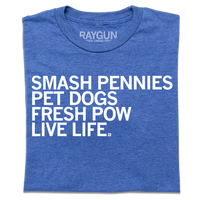 A folded heather royal blue t-shirt with left-aligned white ink text that reads "Smash pennies, pet dogs, fresh pow, live life"