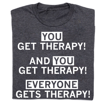 Dark gray Arcus Behavioral Health t-shirt with white text that reads, YOU GET THERAPY! AND YOU GET THERAPY! EVERYONE GETS THERAPY! with the words YOU and EVERYONE enclosed in white rectangles.