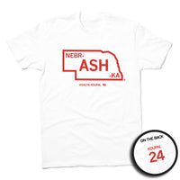 Short sleeve white t-shirt with red ink print outlining Nebraska. Text inside the state says, "NEBR-ASH-KA" with "ASHLYN KOUPAL printed in smaller text below. The back is styled like a jersey with "KOUPAL" printed over the number 24.