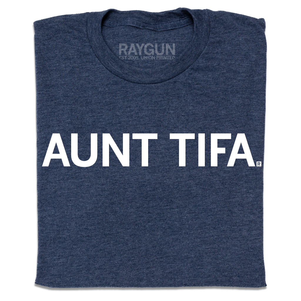 A folded heather navy t-shirt with white ink text that says, " Aunt Tifa"