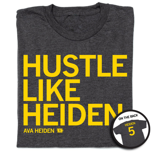 Dark gray union-made t-shirt with golden yellow screen print reading HUSTLE LIKE HEIDEN and AVA HEIDEN 5, with an inset showing the back of the shirt featuring HEIDEN 5.