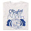 Folded heather white t-shirt with blue ink depicting a pigeon looking at its reflection in Cloud Gate with a skyline in the background and "Chicago" above.
