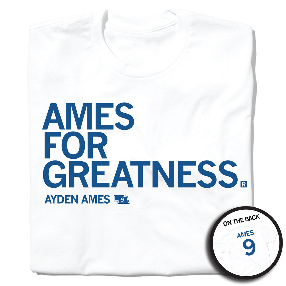 A folded white t-shirt with left-aligned royal blue text that says, "AMES FOR GREATNESS" with "AYDEN AMES" in smaller text below. To the right of her name is an outline of Nebraska with the number "9" in its center. A circular picture to the bottom right shows the back of the shirt. The back is printed like a jersey with "AMES" above a large 9.
