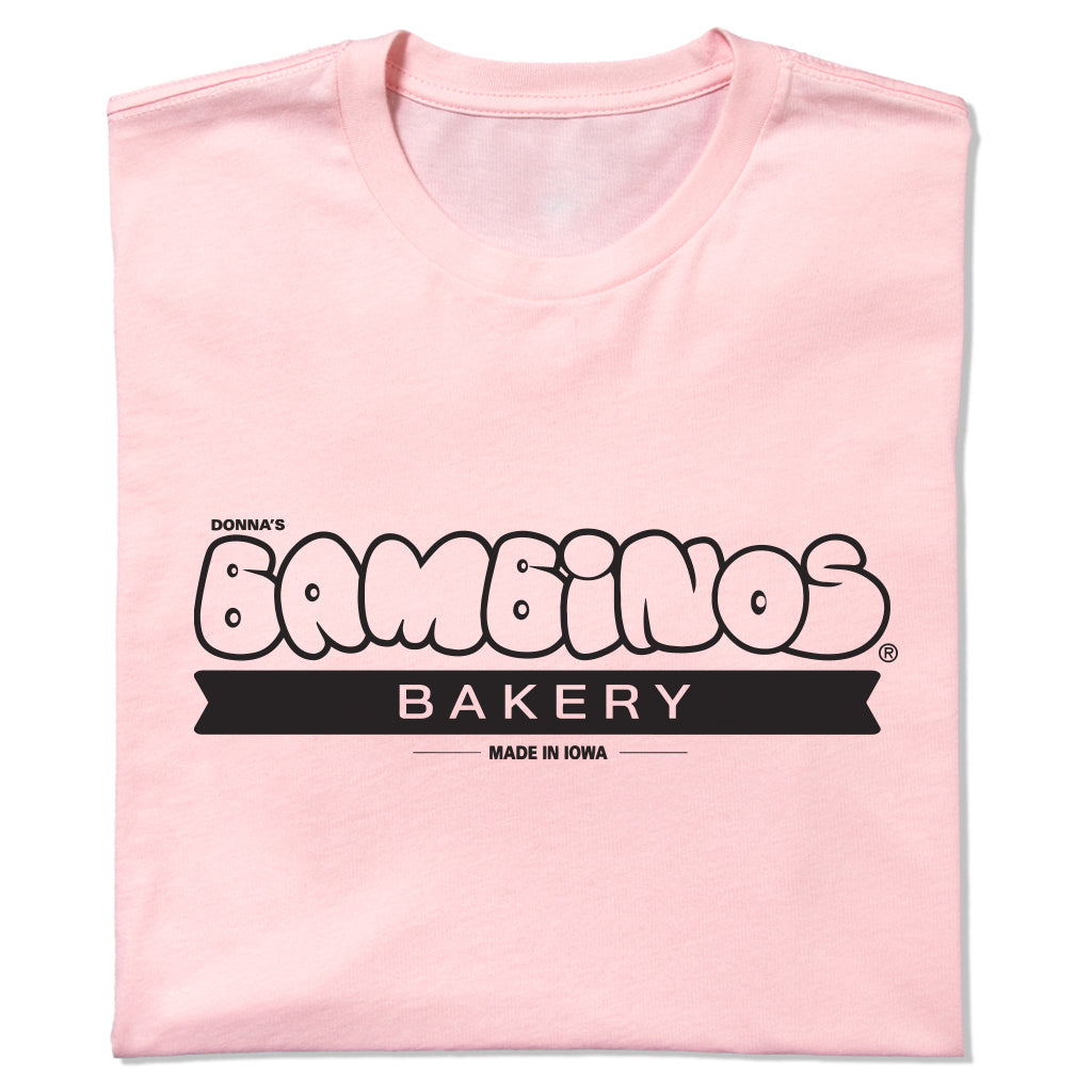 Light pink Donna’s Bambinos Bakery t-shirt with a black logo that reads Made in Iowa.