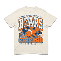 A ivory heavyweight t-shirt with a large orange & navy text that reads "Bear down, Chicago. Bears. Chicago. Est football 1920" over a graphic of a superfan holding a slice of deep dish pizza while riding a bear.