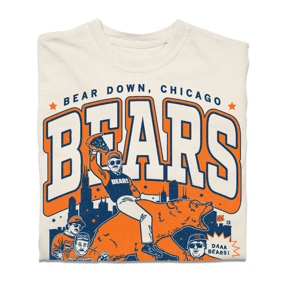 A Comfort Colors Ivory shirt with a large orange & navy graphic. of the SNL superfans riding a bear in front of the Chicago skyline. 