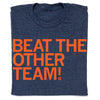 A folded, union-made navy blue RAYGUN t-shirt with the orange text BEAT THE OTHER TEAM! printed on the front.
