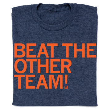 A folded, union-made navy blue RAYGUN t-shirt with the orange text BEAT THE OTHER TEAM! printed on the front.