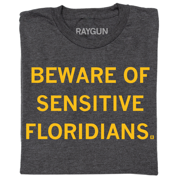 A folded charcoal t-shirt with centered gold ink text that reads 