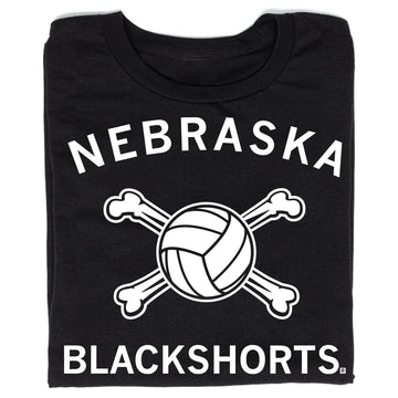 Black t-shirt with white text reading NEBRASKA above a volleyball crossed with two bones, and BLACKSHORTS below.