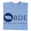 Light blue Union Labor t-shirt with a navy Blue Dot Energy logo featuring the outline of Nebraska inside a circle, the letters BDE, and the brand text.