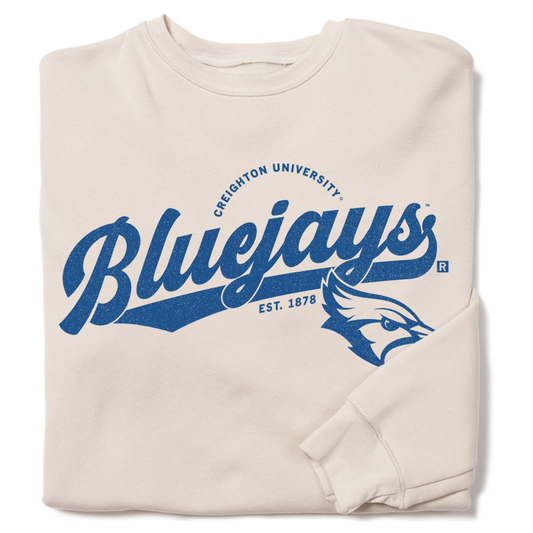Heather dust beige crewneck sweatshirt featuring Creighton University text and a royal blue bluejay mascot logo.