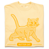 A folded pastel yellow t-shirt with gold ink printed  a gradient depicting a cat made of butter. Text below says, "BUTTER CAT."