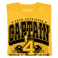 Gold shirt with black ink that reads "Koen Entrigner. Captain Koen. Defensive Back. Ypsilanti, MI" over an illustration of a football field with a large number 4 in the center and a football helmet to either side.