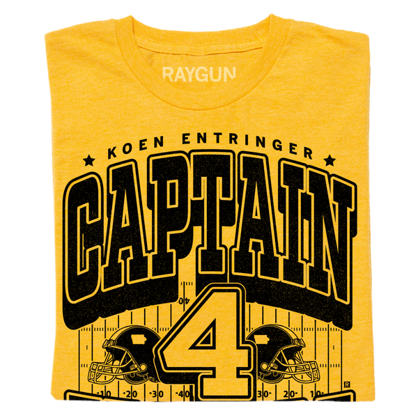 Gold shirt with black ink that reads 