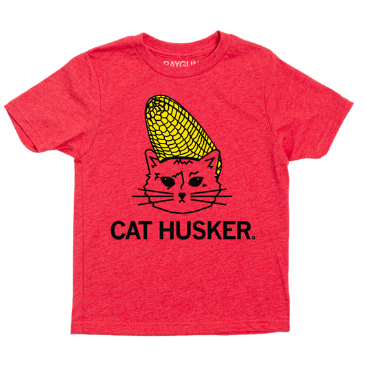 Heather red t-shirt featuring a graphic of a cat with a piece of corn on its head and the text CAT HUSKER below.