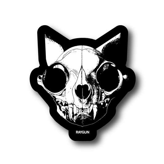 Black and white vinyl sticker of a cat skull with the word RAYGUN at the bottom.