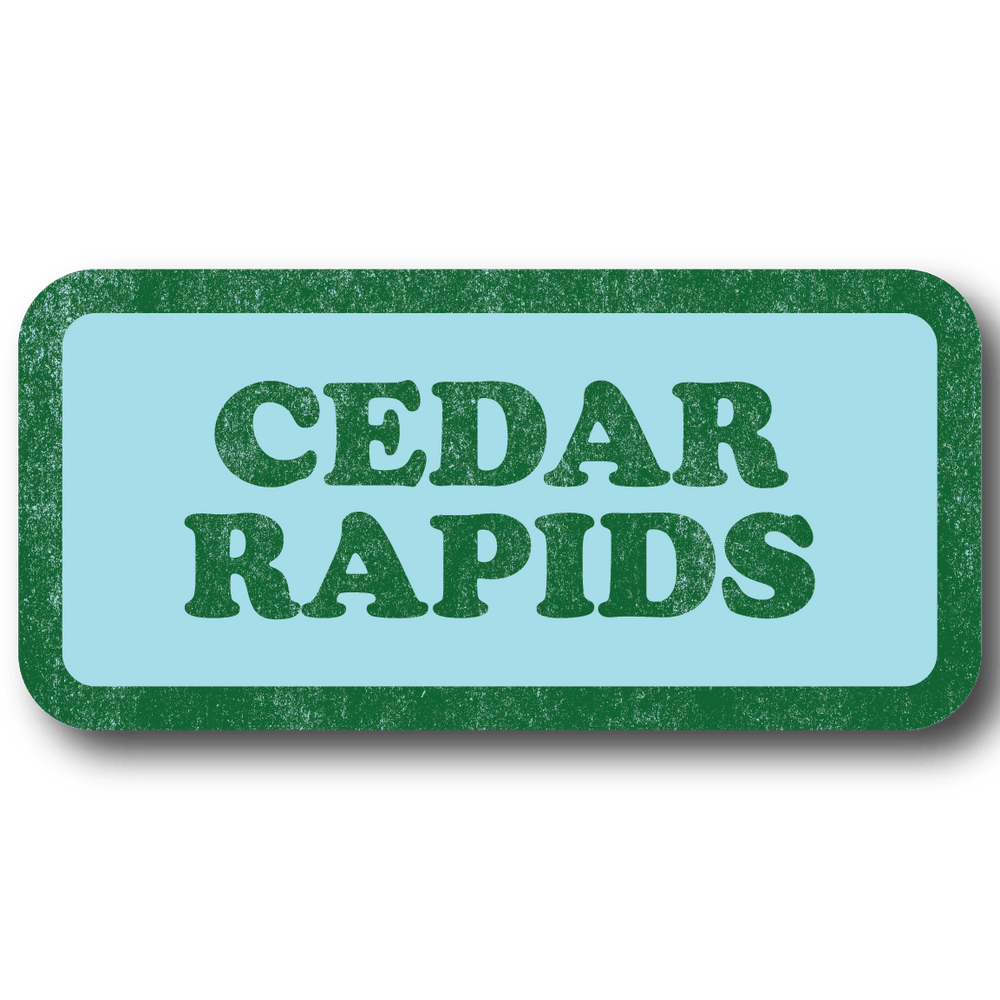 A rectangular light blue sticker with a faded green border and faded green text that says, "CEDAR RAPIDS" in a vintage look.
