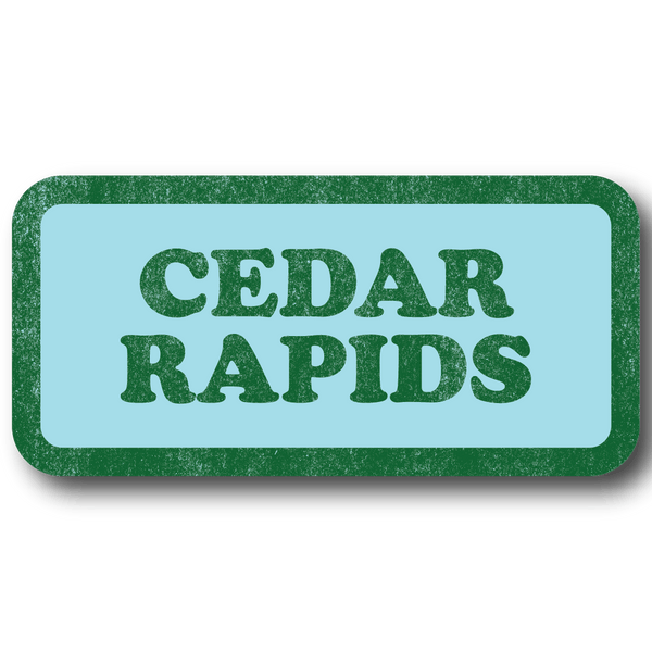 A rectangular light blue sticker with a faded green border and faded green text that says, 
