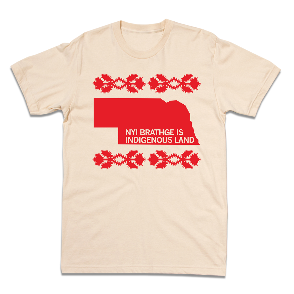 Short sleeve cream t-shirt with bright red ink print of Nebraska with cream text over the bottom of the state that says, "NYI BRATHGE IS INDIGENOUS LAND". 